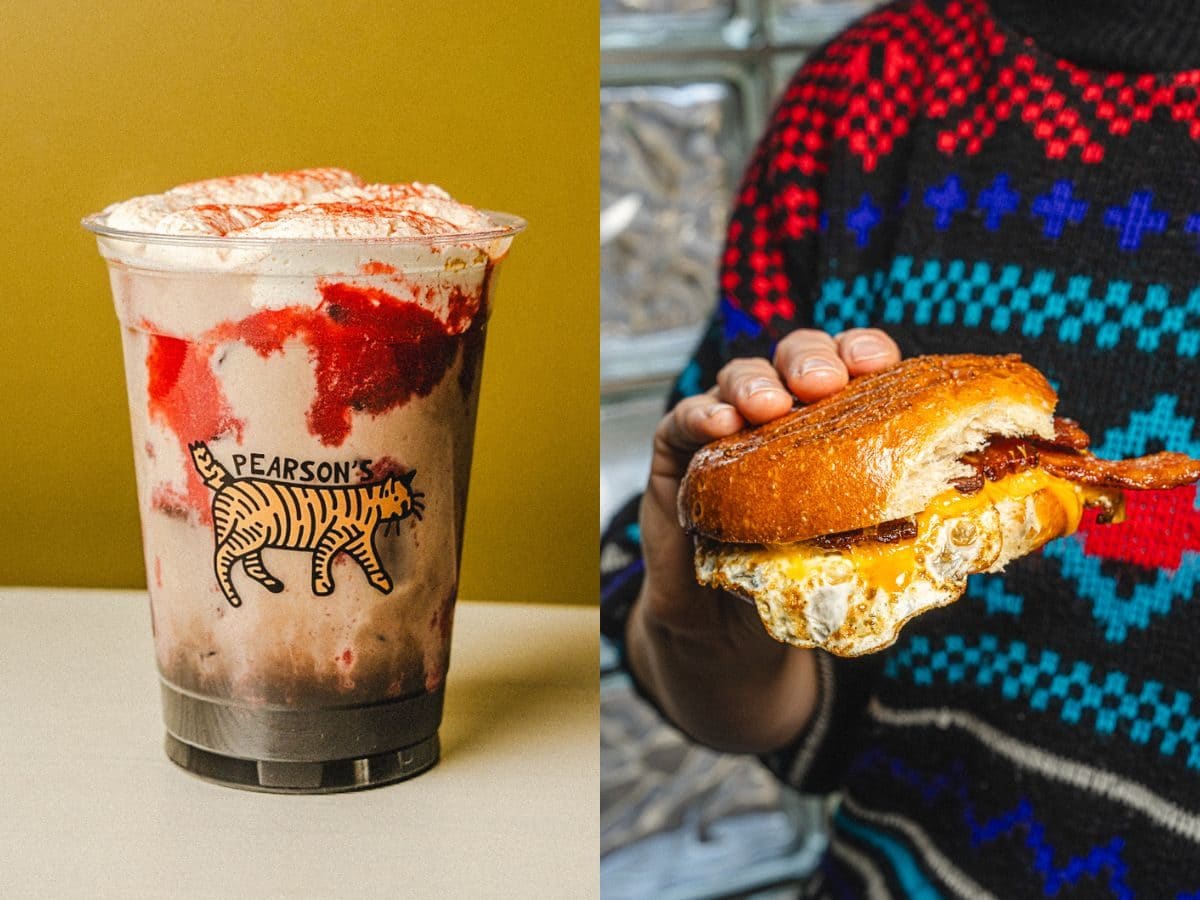 A latte with a red swirl beside a bacon, egg, and cheese on brioche